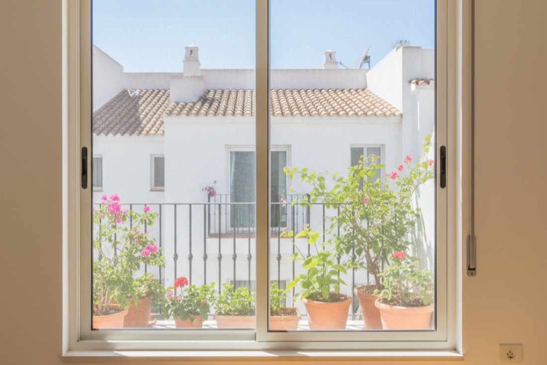 Mosquitera instalada en una ventana de una vivienda de El Prat de Llobregat con vista al balcón
